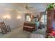 This bright main bedroom features sconce lighting, an ornate wood bed, a sitting bench and a rocking chair for relaxing at 3008 Imperial Dr, Gastonia, NC 28054