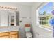 Well-lit bathroom with a single window, toilet, and extended vanity at 3129 Summerfield Ridge Ln, Matthews, NC 28105