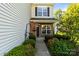 Inviting entryway of this two-story townhome with brick accents, lush greenery, and a cozy, welcoming porch at 3129 Summerfield Ridge Ln, Matthews, NC 28105