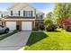Charming two-story townhome with manicured lawn, attached garages, and inviting curb appeal on a sunny day at 3129 Summerfield Ridge Ln, Matthews, NC 28105