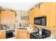 This kitchen features light wood cabinets, black appliances, and light countertops at 3129 Summerfield Ridge Ln, Matthews, NC 28105