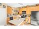Charming kitchen features an island, light wood cabinets, and black appliances at 3129 Summerfield Ridge Ln, Matthews, NC 28105