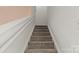 Carpeted staircase with a white handrail leads to the upper level of the home at 3129 Summerfield Ridge Ln, Matthews, NC 28105
