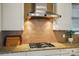 Stove top inset into granite counter top features stainless hood vent at 330 Horton Grove Rd, Fort Mill, SC 29715