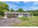 Exterior view of the home with a carport, screened in porch, and beautiful greenery at 335&315 Graham Rd, Mt Ulla, NC 28125