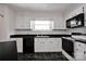 Charming kitchen with white cabinets, black countertops, and classic appliances, seamlessly combining functionality and a timeless design at 335&315 Graham Rd, Mt Ulla, NC 28125