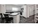Retro kitchen with white cabinetry, black countertops, and a unique black and white tiled backsplash, creating a classic, stylish space at 335&315 Graham Rd, Mt Ulla, NC 28125