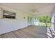 View of the screened porch with wooden flooring, ceiling fan, and a door leading to the backyard at 335&315 Graham Rd, Mt Ulla, NC 28125