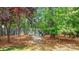 A picturesque backyard firepit with seating surrounded by mature trees at 3617 Ruth St, Indian Trail, NC 28079