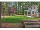 Large backyard features a pergola-covered patio, raised garden beds, and a wooded backdrop at 3617 Ruth St, Indian Trail, NC 28079