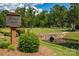 Scenic Russell Park sign by a picturesque stone bridge over a tranquil stream and lush greenery at 3617 Ruth St, Indian Trail, NC 28079