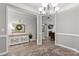 Inviting dining room open to living area, featuring elegant trimwork, light gray paint, and wood floors at 3820 Leela Palace Way, Fort Mill, SC 29708