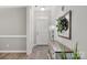 Inviting entryway featuring neutral gray walls, wood floors, a decorative table and lamp, and a white front door at 3820 Leela Palace Way, Fort Mill, SC 29708