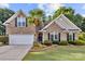 Charming brick home featuring a manicured lawn with a variety of bushes and a beautifully landscaped flower bed at 3820 Leela Palace Way, Fort Mill, SC 29708