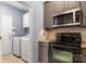 Well-equipped kitchen featuring stainless steel appliances, a microwave, and washer/dryer in the laundry room at 3820 Leela Palace Way, Fort Mill, SC 29708