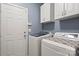 Convenient laundry room featuring modern washer and dryer, ample white cabinetry, and a utility sink at 3820 Leela Palace Way, Fort Mill, SC 29708