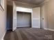 An open closet with bi-fold doors, plush carpet, and a rod, offering ample storage solutions at 404 Kings Dr # 7, Cherryville, NC 28021