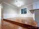 An open-concept dining room featuring chair rail molding, hardwood floors, and a large window at 404 Kings Dr # 7, Cherryville, NC 28021