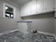 Well-lit laundry room features ample cabinet storage space and stylish gray flooring at 404 Kings Dr # 7, Cherryville, NC 28021