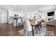 Open-concept dining area features modern chairs and a wooden table next to the kitchen and living room at 446 Misty Law Ln, Clover, SC 29710