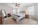 Bright, carpeted bedroom with a ceiling fan, complemented by curtains, lamps, and a luxurious bed with stylish throw blanket at 446 Misty Law Ln, Clover, SC 29710