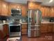 Well-lit kitchen featuring wood cabinets, stainless steel appliances, granite countertops, and hardwood floors at 517 Grassy Creek Run, Chester, SC 29706