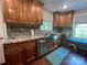 A kitchen featuring a stainless steel sink, wooden cabinets, granite countertops, and tiled backsplash at 517 Grassy Creek Run, Chester, SC 29706