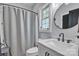 Well-lit bathroom with a shower-tub combo featuring updated fixtures, a modern sink, and a window at 5262 Mckenzie Trl, Conover, NC 28613
