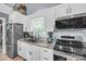 Close-up of kitchen featuring stainless steel appliances, granite counters, white cabinets, and tile backsplash at 5262 Mckenzie Trl, Conover, NC 28613