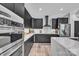 Modern kitchen with marble countertops, black cabinets, hardwood floors and stainless appliances at 5262 Mckenzie Trl, Conover, NC 28613