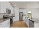 Bright kitchen with stainless steel appliances, granite counters, an island and white cabinetry at 5606 Skinny Dr, Charlotte, NC 28215