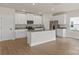 Bright kitchen featuring granite counters, an island, white cabinetry, and stainless appliances at 5606 Skinny Dr, Charlotte, NC 28215