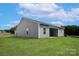 The back of the house has gray siding, a covered patio, and a spacious lawn at 5607 Skinny Dr, Charlotte, NC 28215
