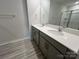Bathroom featuring double vanity, large mirror, and a combination shower with glass door and wood-look flooring at 578 Sparkleberry St, Chester, SC 29706