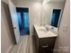 Bathroom featuring double vanity, large mirror, and grey wood-look flooring with a door leading to another room at 578 Sparkleberry St, Chester, SC 29706