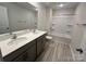 Bathroom featuring double vanity, large mirror, a shower and tub combination with grey wood-look flooring at 578 Sparkleberry St, Chester, SC 29706