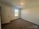 Bedroom showcasing neutral walls, brown carpet, a window, and a door creating a cozy and comfortable space at 578 Sparkleberry St, Chester, SC 29706
