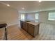 Kitchen island with granite countertop, stainless steel sink, and gray cabinets and wood-look flooring at 578 Sparkleberry St, Chester, SC 29706