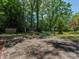 Spacious backyard featuring a stone patio surrounded by lush greenery, offering a tranquil outdoor living space at 6001 Charing Pl, Charlotte, NC 28211