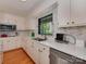 Modern kitchen featuring white cabinetry, quartz countertops and stainless steel appliances at 6001 Charing Pl, Charlotte, NC 28211