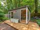 Modern outbuilding with a deck, large windows, and a pop of red from an exterior light at 6001 Charing Pl, Charlotte, NC 28211
