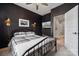 Modern bedroom boasts dark walls, stylish sconces, and a comfy bed with a plaid comforter at 614 West End Dr, Charlotte, NC 28208