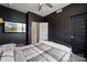 Dark walled bedroom with mounted television and views through the doorway to the staircase at 614 West End Dr, Charlotte, NC 28208