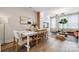 Open floorplan of dining room flows to living area, features contemporary white table and plenty of natural light at 614 West End Dr, Charlotte, NC 28208