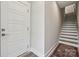 Bright entryway with modern white door, hardwood floors, and staircase at 614 West End Dr, Charlotte, NC 28208