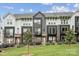 Modern townhome features a stylish gray and white facade, complimented by a well-maintained lawn and black fencing at 614 West End Dr, Charlotte, NC 28208
