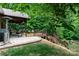 Backyard showcasing the wood deck, stone patio, professional landscaping, and a fire pit with chairs at 6398 Winding Creek Ln, Denver, NC 28037
