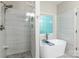 Bright bathroom featuring soaking tub, standalone shower, and a large window with glass blocks at 6398 Winding Creek Ln, Denver, NC 28037