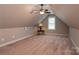 Attic bedroom features neutral carpeting, dormer window, and overhead ceiling fan at 6398 Winding Creek Ln, Denver, NC 28037