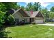 Exterior view of a charming two-story home with a well-manicured lawn, attached garage, and a US flag at 6398 Winding Creek Ln, Denver, NC 28037